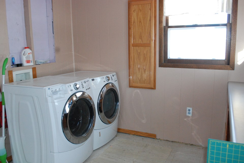 laundry area on main floor with extra storage space