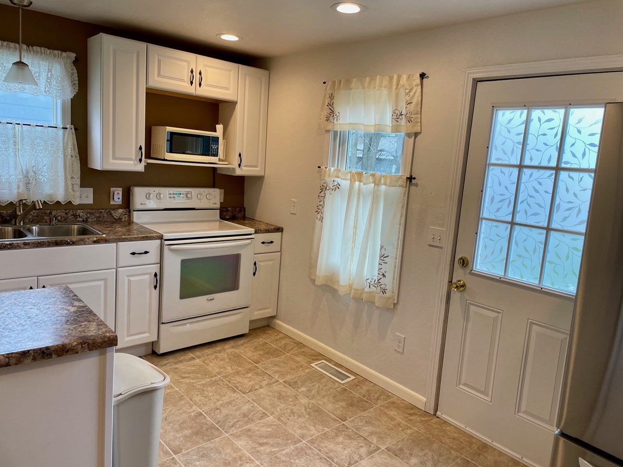 kitchen with door access to backyard and walkway to garage