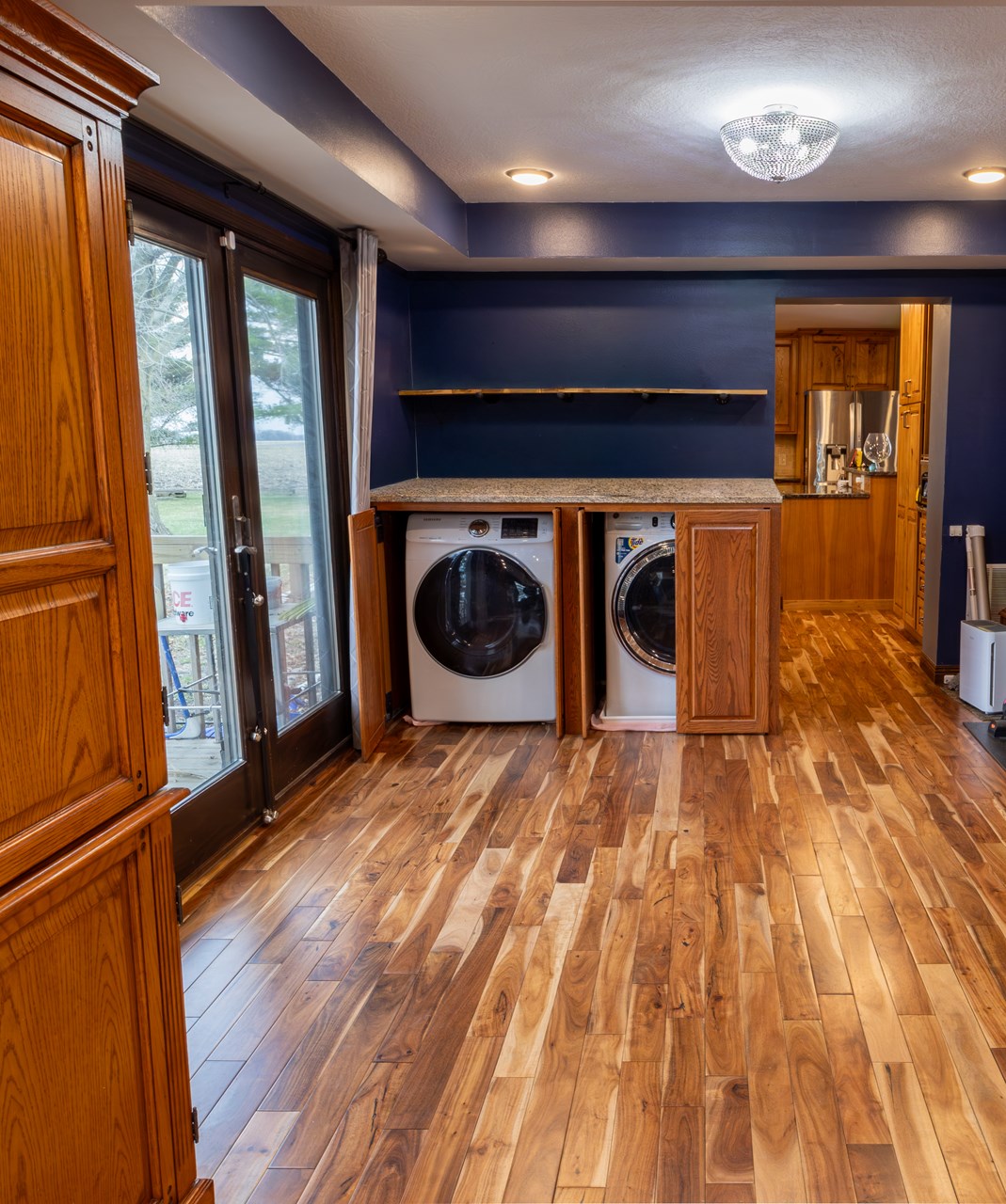 main level laundry cabinet doors close to hide the washing machine and dryer. 
framing and layout near the patio door are in place for a potential addition.