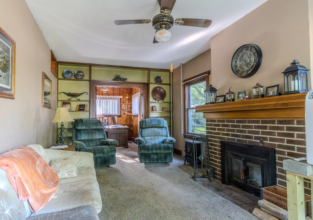 living room with built-in shelving & wood burning fireplace
